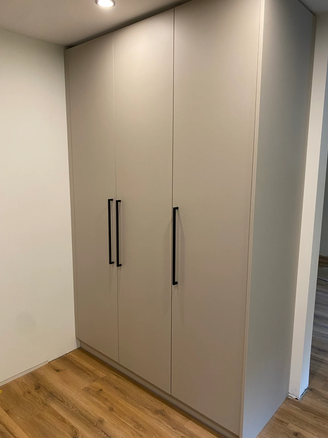 Raumhoher dreitüriger Einbauschrank mit schwarzen Griffen
